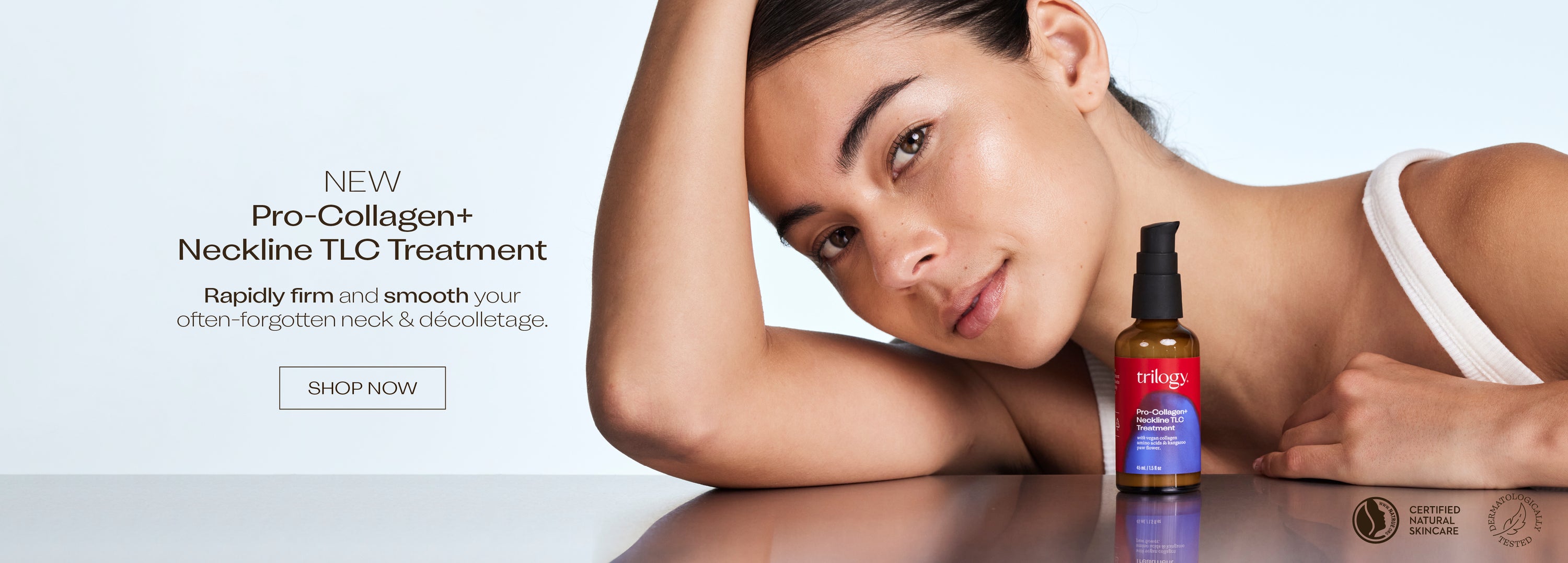 Woman lying on a table with a Pro-Collagen+ Neckline TLC Treatment bottle next to her.